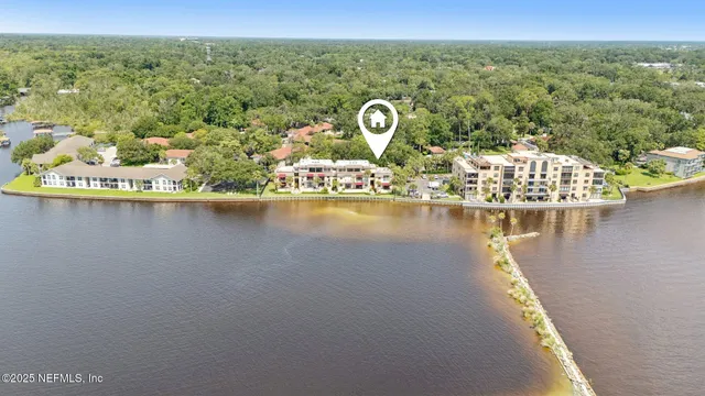 an aerial view of a house with a yard and lake view
