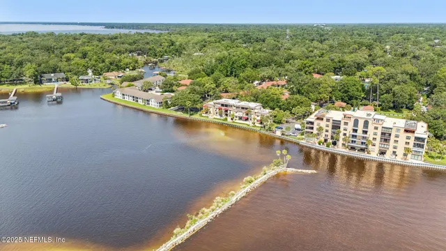 an aerial view of a house with a yard lake and outdoor seating