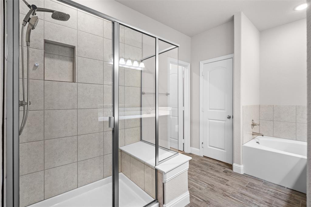 119 Happy Lane Red Oak, TX 75154 - Photo 25 of 37 Glass-enclosed shower with a built-in bench and recessed niche, accompanied by a separate soaking tub