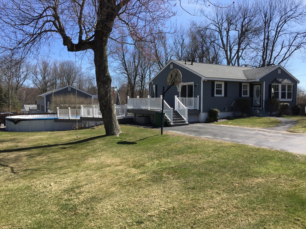 a view of a house with a yard covered with trees