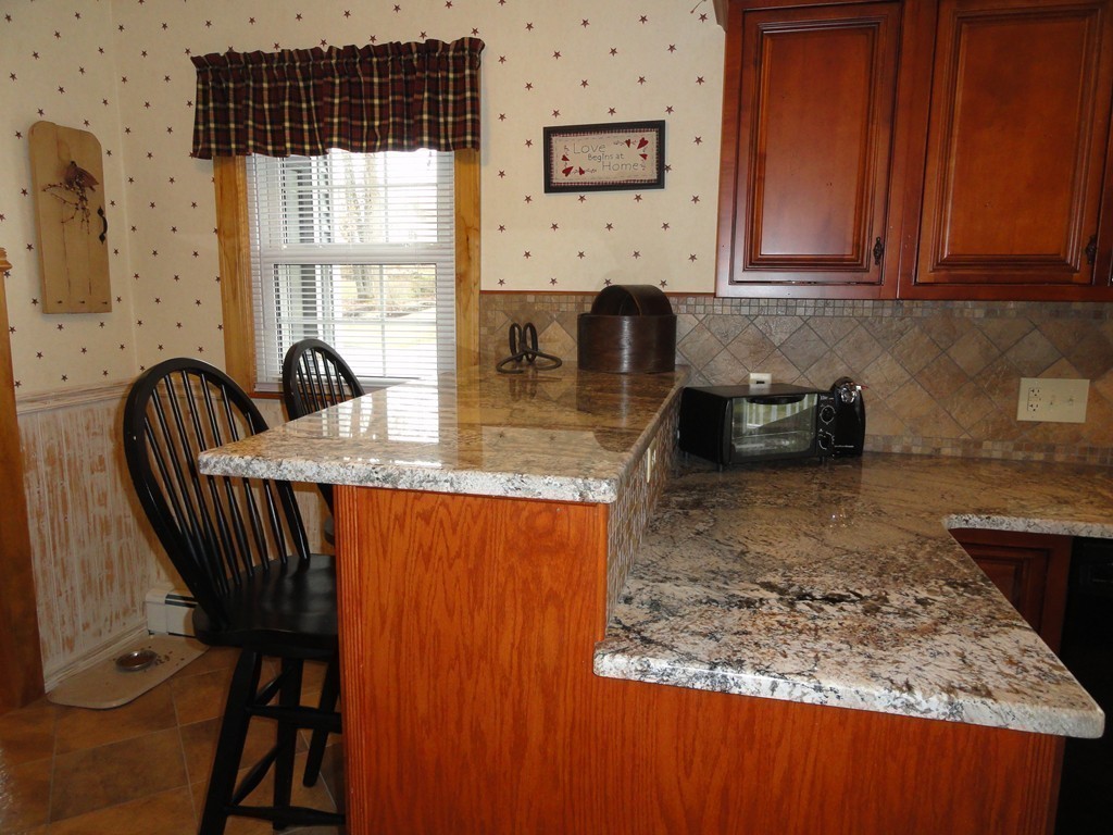 12 Laurelwood Road Rutland, MA 01543 - Photo 10 of 25 a kitchen with granite countertop a stove a sink a dining table and chairs
