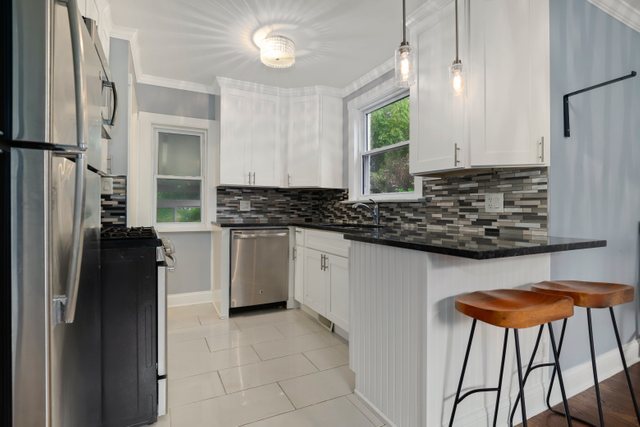 306 North Elmhurst Road Prospect Heights, IL 60070 - Photo 6 of 26 a kitchen with stainless steel appliances granite countertop a refrigerator and a stove top oven