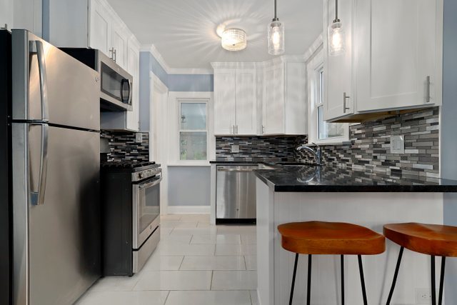 306 North Elmhurst Road Prospect Heights, IL 60070 - Photo 7 of 26 a kitchen with stainless steel appliances granite countertop a refrigerator a sink a stove and a wooden cabinets