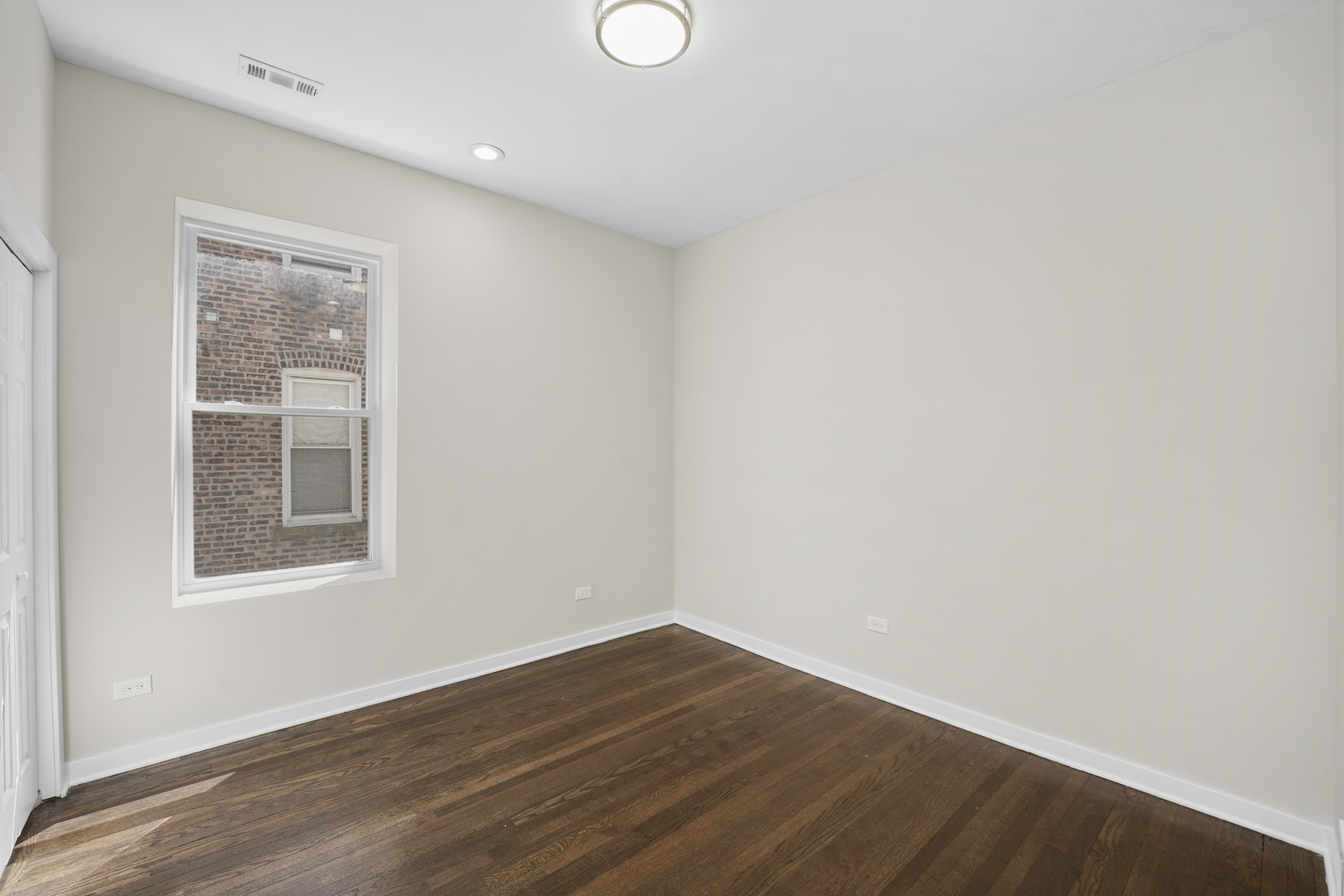 6014 South Prairie Avenue, Unit 2 Chicago, IL 60637 - Photo 4 of 10 an empty room with wooden floor and windows