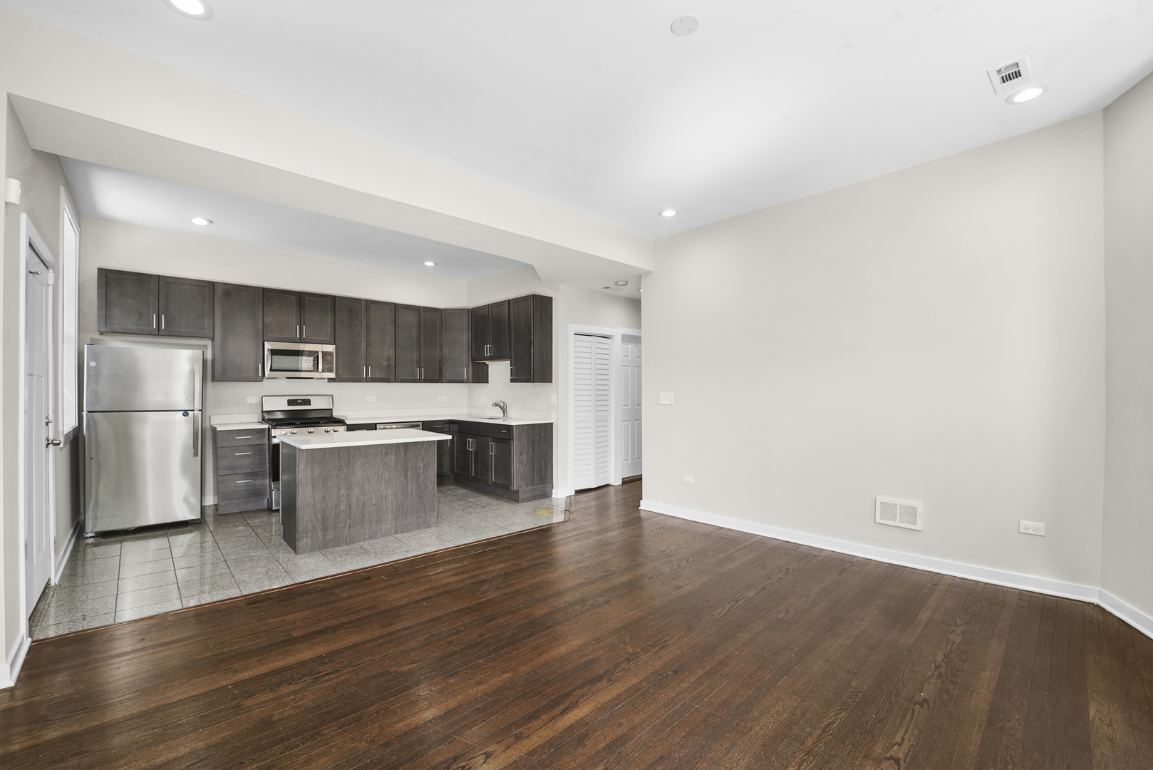6014 South Prairie Avenue, Unit 2 Chicago, IL 60637 - Photo 8 of 10 a kitchen with stainless steel appliances wooden floor sink and stove