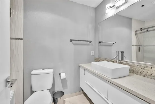 a bathroom with a sink mirror vanity and toilet