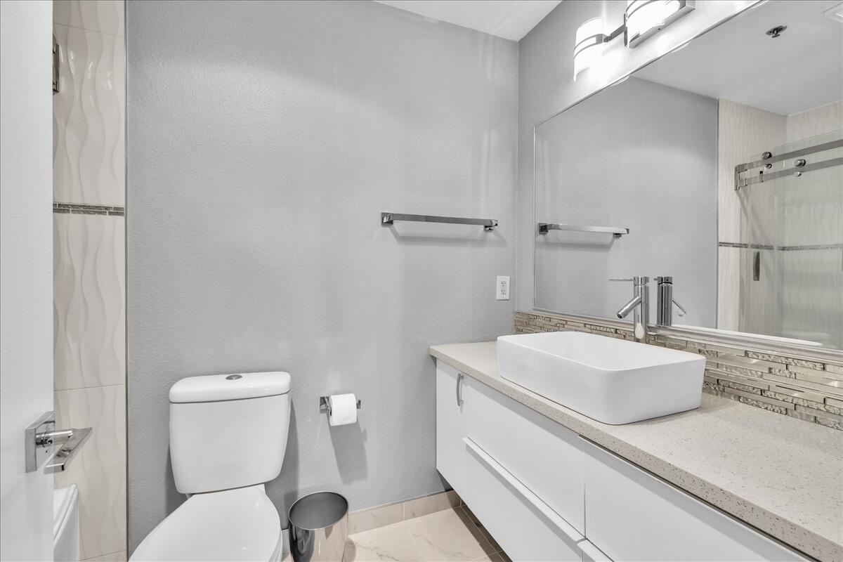 500 East Amado Road, Unit 416 Palm Springs, CA 92262 - Photo 21 of 48 a bathroom with a sink mirror vanity and toilet