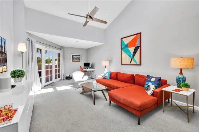 a living room with furniture a lamp and a potted plant