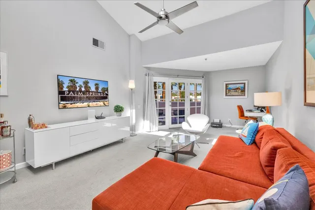 a living room with furniture a flat screen tv and a couch