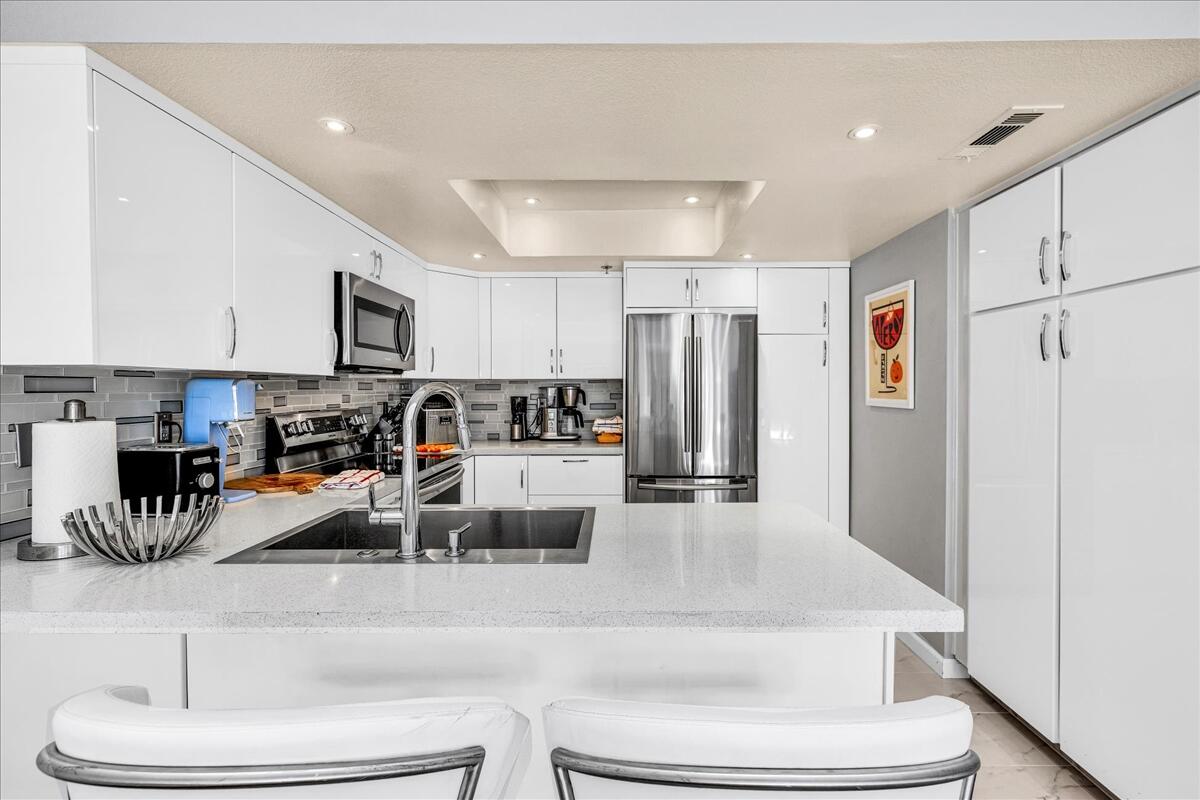 500 East Amado Road, Unit 416 Palm Springs, CA 92262 - Photo 8 of 48 a living room with stainless steel appliances lots of white furniture and a refrigerator