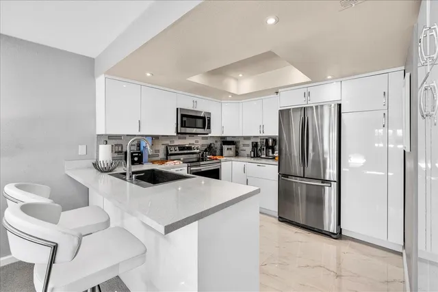 a kitchen with a refrigerator a microwave a sink and cabinets