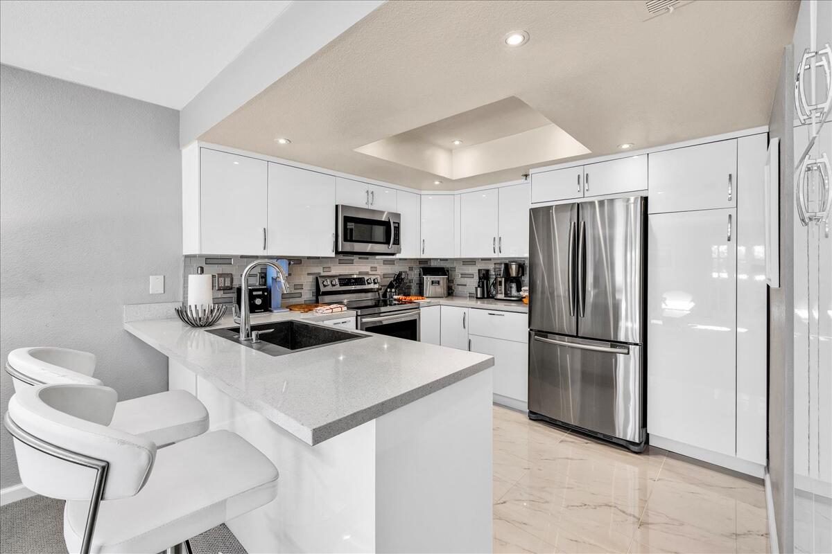 500 East Amado Road, Unit 416 Palm Springs, CA 92262 - Photo 9 of 48 a kitchen with a refrigerator a microwave a sink and cabinets