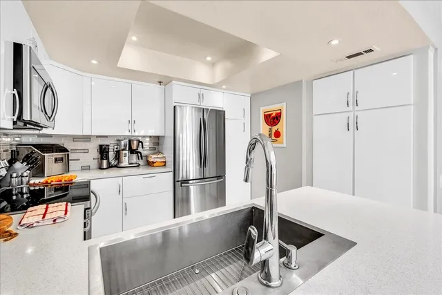 a kitchen with stainless steel appliances granite countertop a refrigerator and a stove top oven