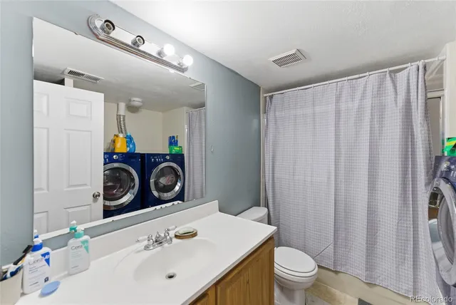a bathroom with a sink a toilet and shower curtain
