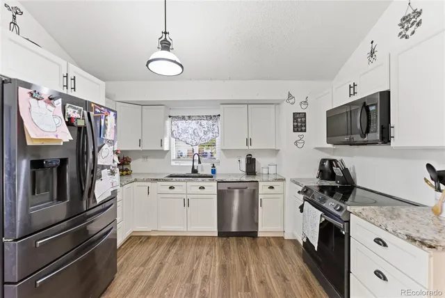a kitchen with stainless steel appliances granite countertop a stove refrigerator sink and microwave