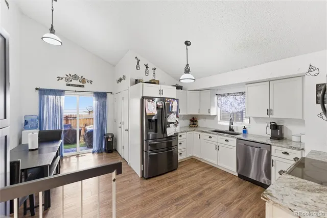 a kitchen with stainless steel appliances granite countertop a sink a stove and refrigerator