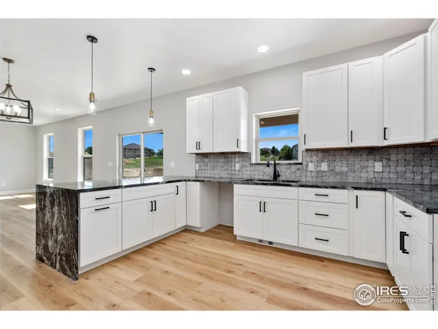 a kitchen with stainless steel appliances granite countertop a stove a sink and white cabinets