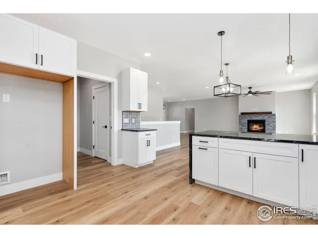 a open kitchen with kitchen island white cabinets and a chandelier