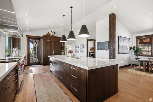 7885 North Rabbitbrush Court, Unit 13 Park City, UT 84098 - Photo 14 of 88 Gourmet kitchen featuring a large central island with a light-toned countertop, dark wood-finish cabinetry, and stainless steel appliances