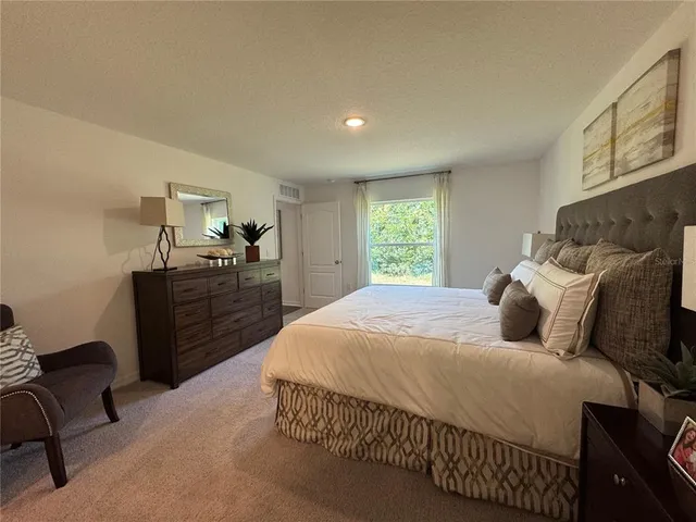 a bedroom with a bed and a chair