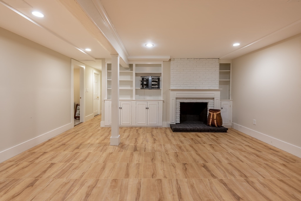 37 Forster Road Manchester, MA 01944 - Photo 39 of 42 a view of empty room with wooden floor and fireplace