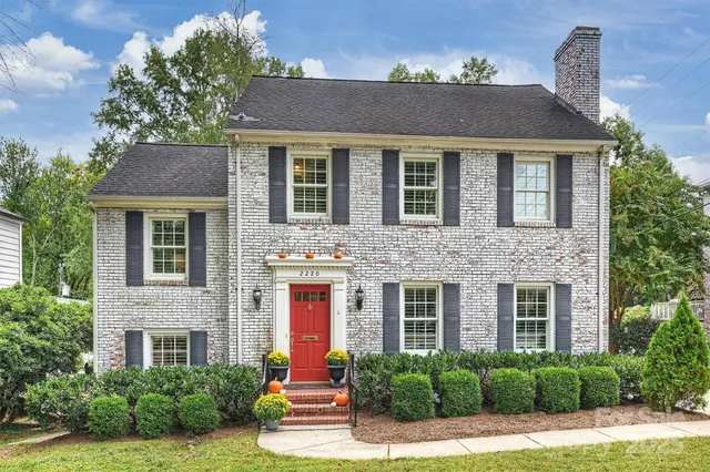 a front view of a house with a yard and trees
