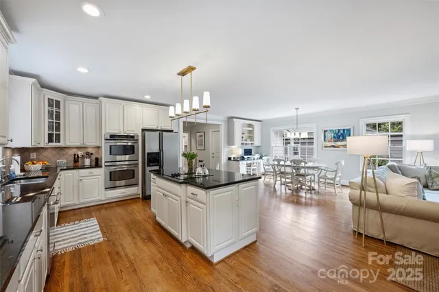 a kitchen with stainless steel appliances kitchen island granite countertop a stove and cabinets