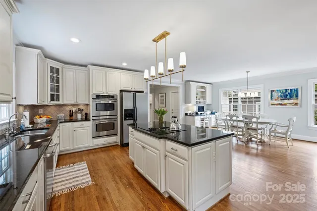 a kitchen with stainless steel appliances kitchen island granite countertop a stove and cabinets