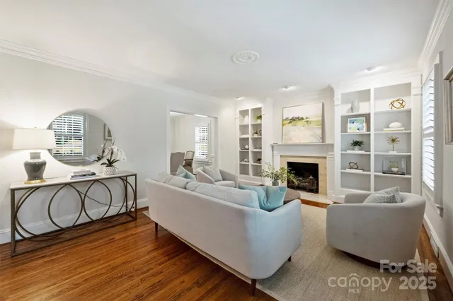 a living room with furniture a fireplace and a floor to ceiling window