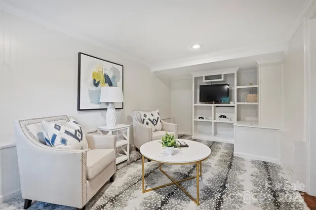 a living room with furniture and a dining table with rug
