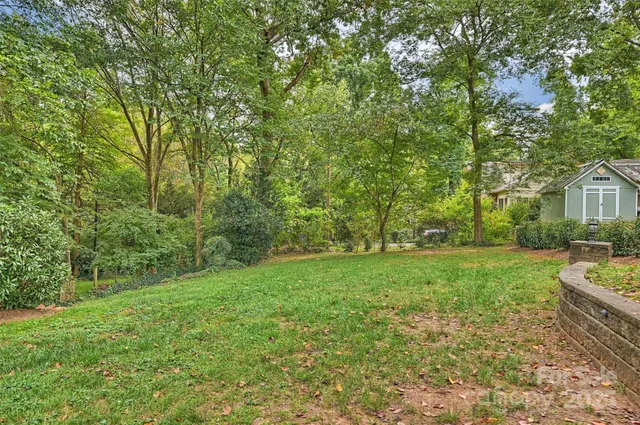 a view of a backyard with table and chairs and wooden fence
