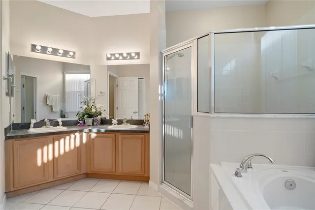 a spacious bathroom with a tub sink and mirror