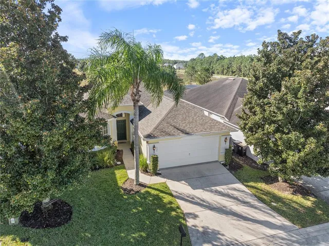 a front view of a house with a garden and trees