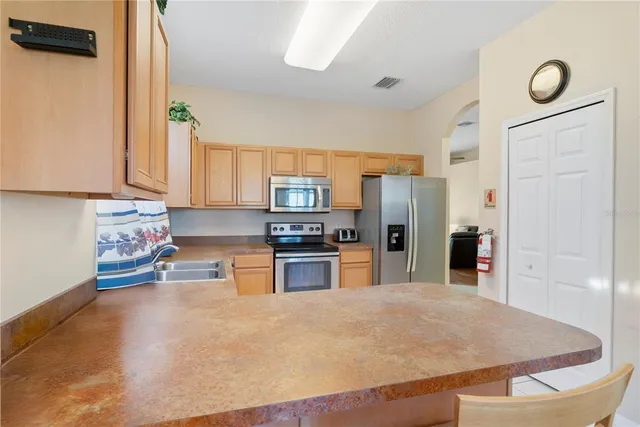 a kitchen with stainless steel appliances granite countertop a refrigerator sink and stove