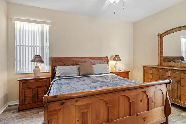 a bedroom with a bed a mirror on dresser and a window