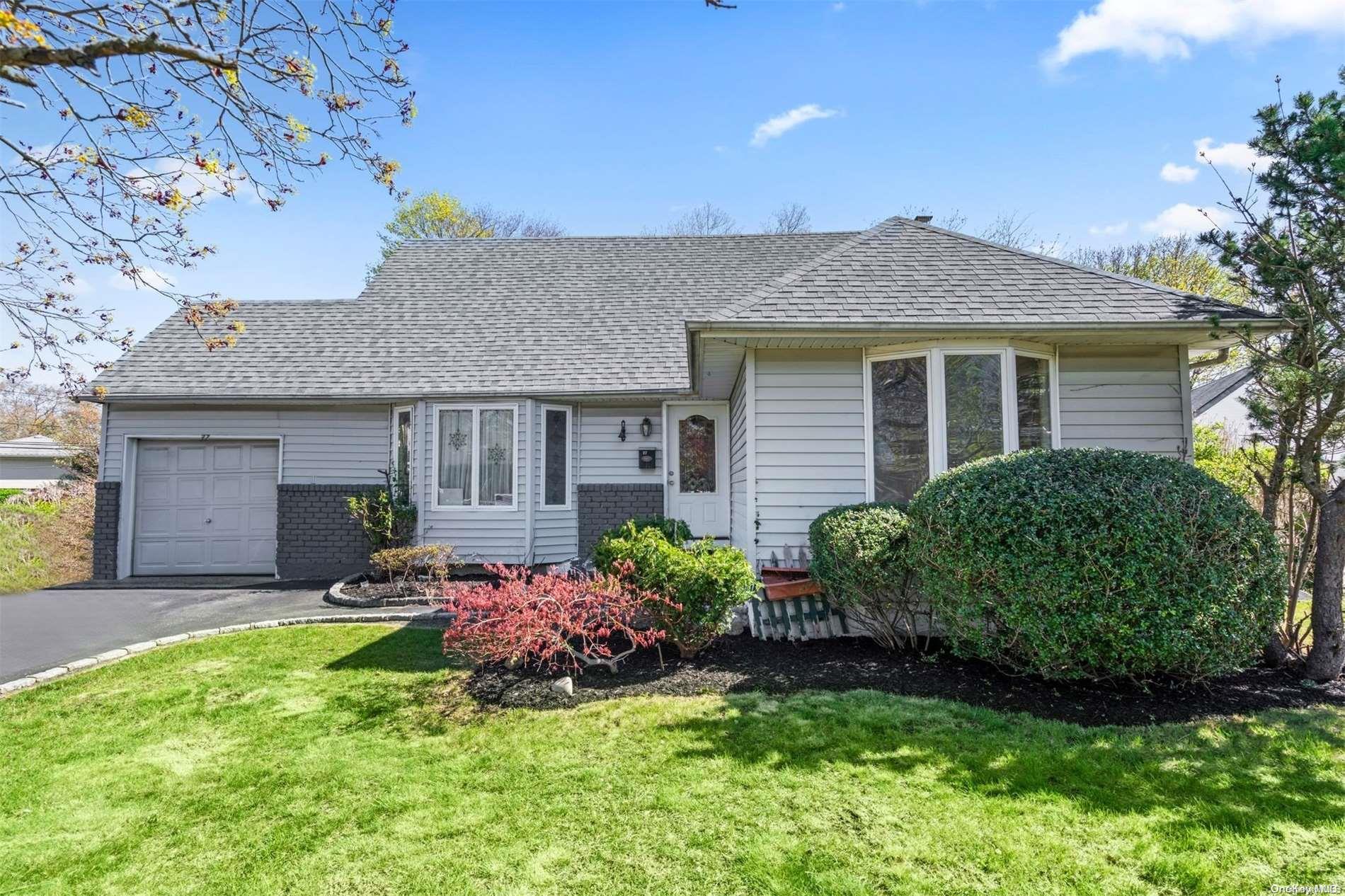 a front view of a house with a garden and plants