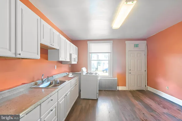 a kitchen with granite countertop a stove a sink and a refrigerator