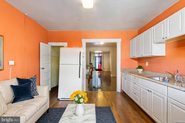 a kitchen with kitchen island wooden floor center island and stainless steel appliances