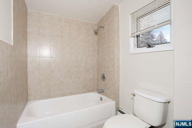 68 Mohawk Avenue, Unit 2 Hawthorne, NJ 07506 - Photo 13 of 24 a white bath tub sitting next to a white toilet