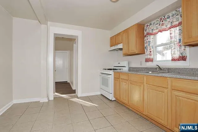 a kitchen with granite countertop a sink and a stove top oven