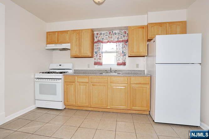 68 Mohawk Avenue, Unit 2 Hawthorne, NJ 07506 - Photo 6 of 24 a kitchen with a refrigerator sink stove and cabinets