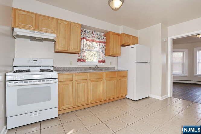 68 Mohawk Avenue, Unit 2 Hawthorne, NJ 07506 - Photo 7 of 24 a kitchen with white cabinets and white appliances