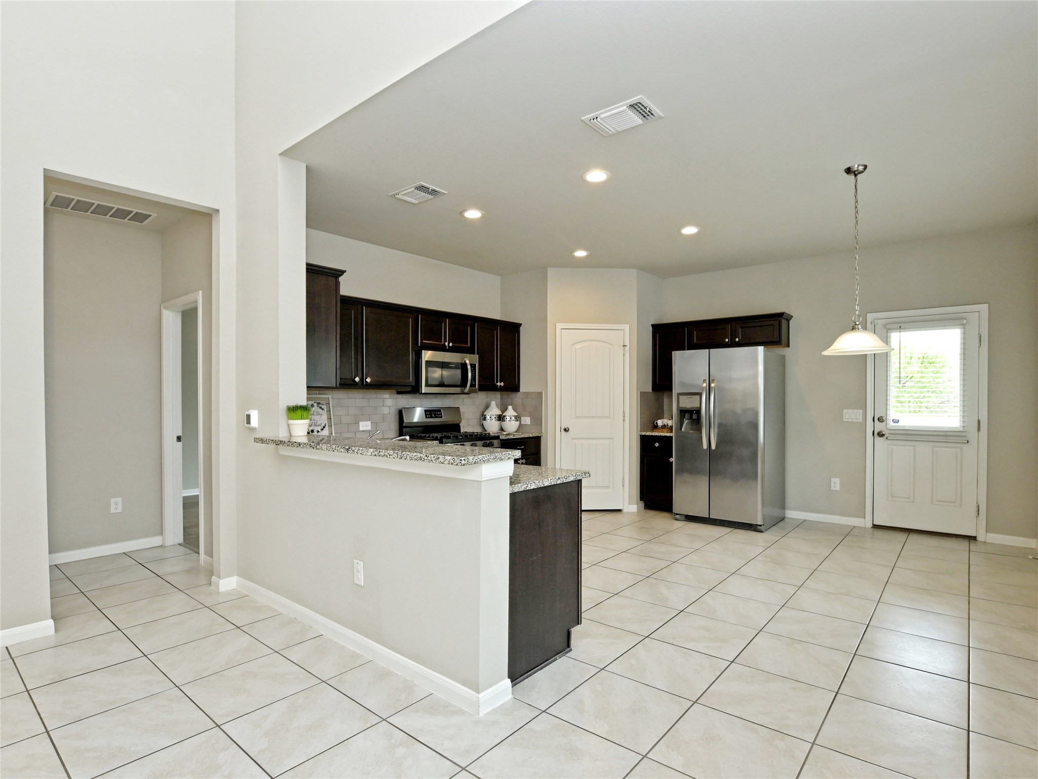 6917 Ranchito Drive Austin, TX 78744 - Photo 9 of 29 Kitchen and breakfast area, shows the refrigerator that is included