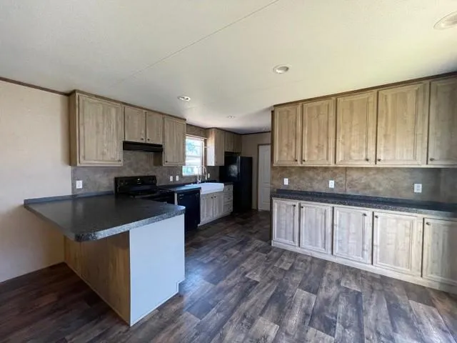 a kitchen with cabinets and wooden floor