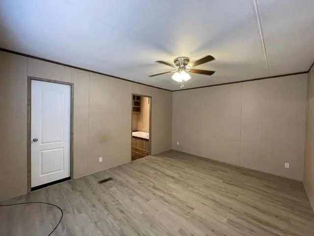 an empty room with windows and fan