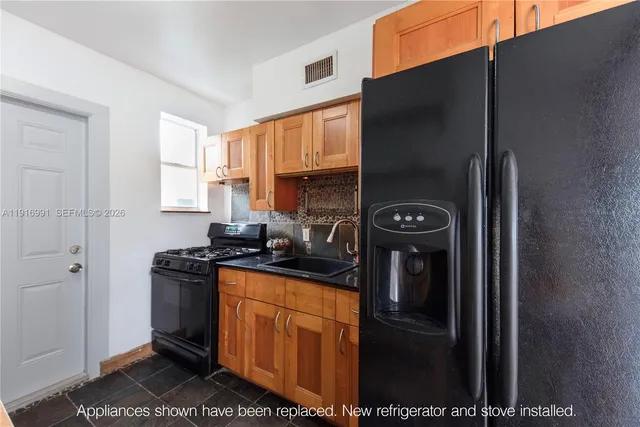 a kitchen with stainless steel appliances granite countertop a refrigerator and a stove