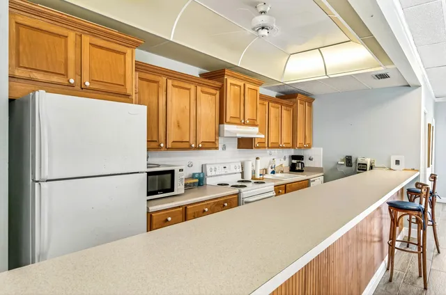 a kitchen with a refrigerator a stove a sink dishwasher and wooden cabinets