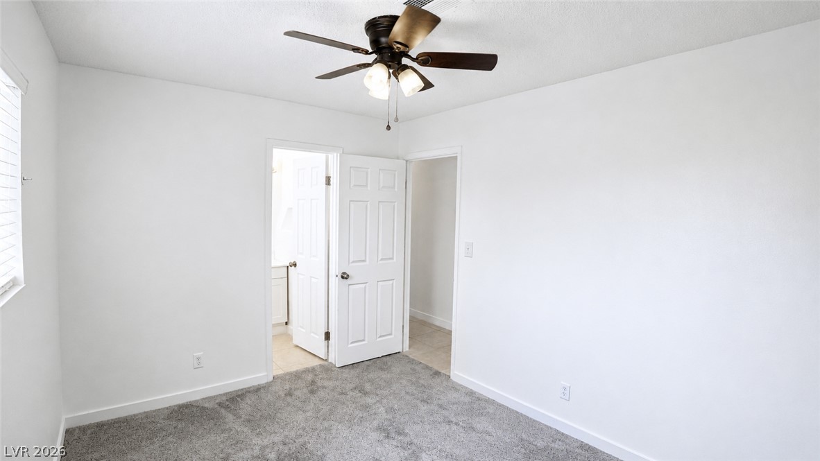 2870 South Sandhill Road Las Vegas, NV 89121 - Photo 55 of 64 A well-lit bedroom features plush carpeting and a convenient ceiling fan.