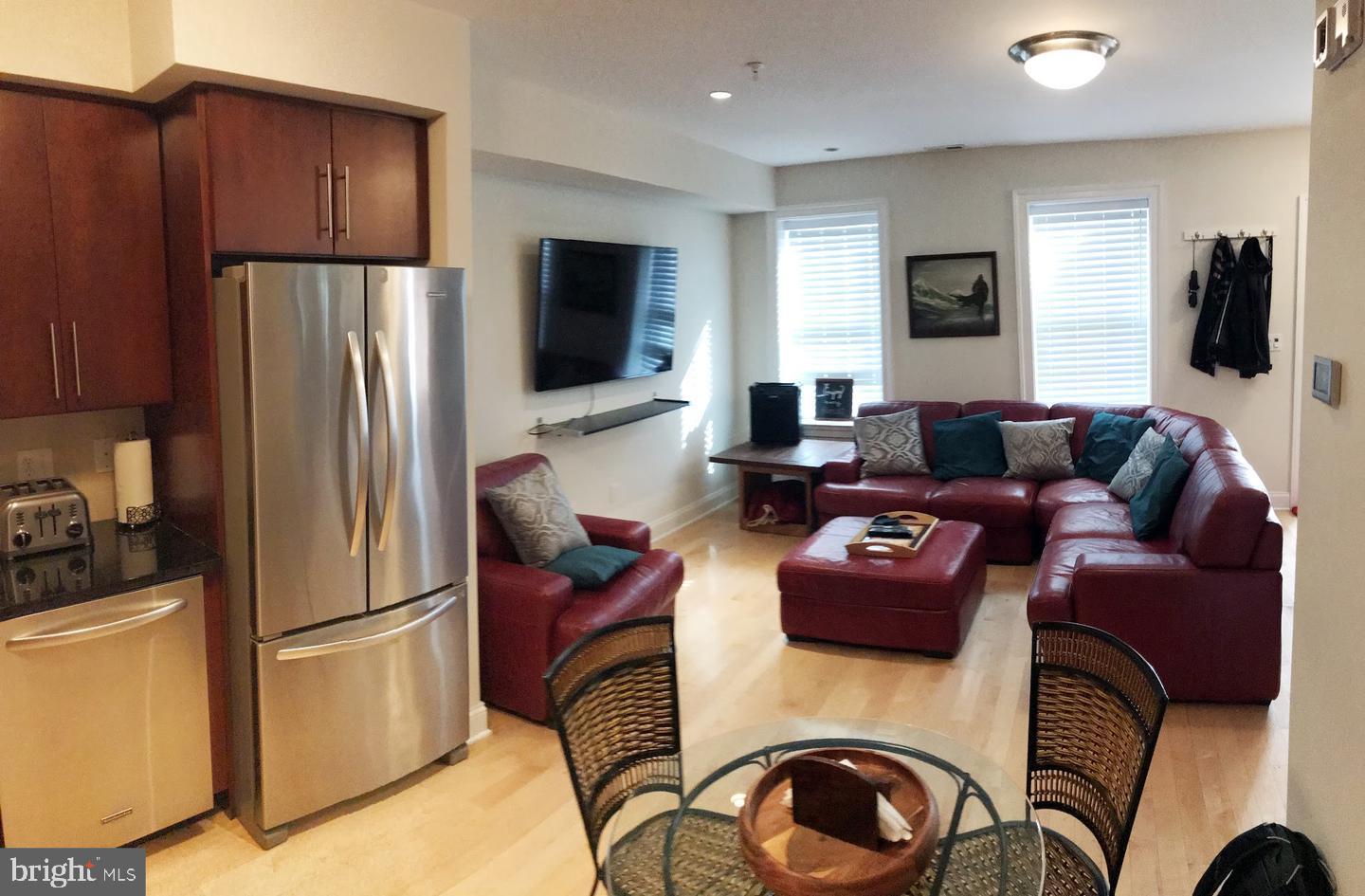 3925 Fulton Street Northwest, Unit 5 Washington, DC 20007 - Photo 5 of 19 a living room with furniture a flat screen tv and a refrigerator