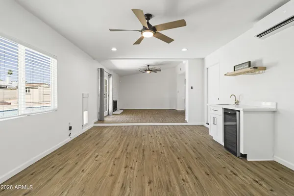 an empty room with a window and a fan